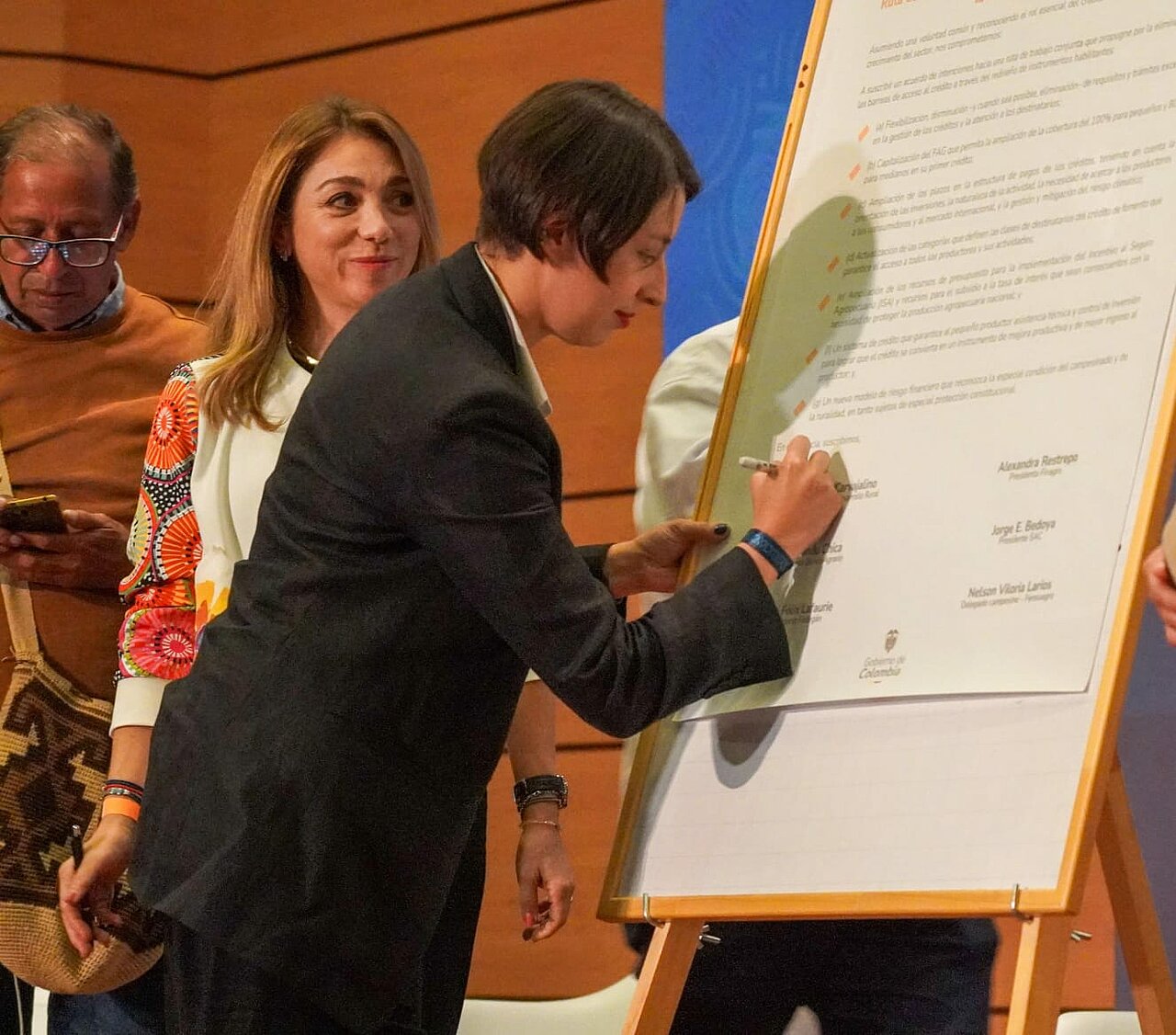 En la imagen se muestra la ministra firmando