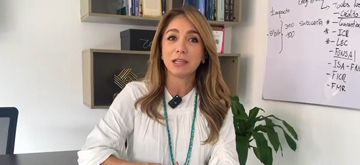 En la imagen se puede ver a una mujer la cual esta en su oficina, mientras habla. 