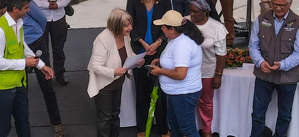 La ministra de agricultura Cecilia López aparece entregando titulo a mujer campesina