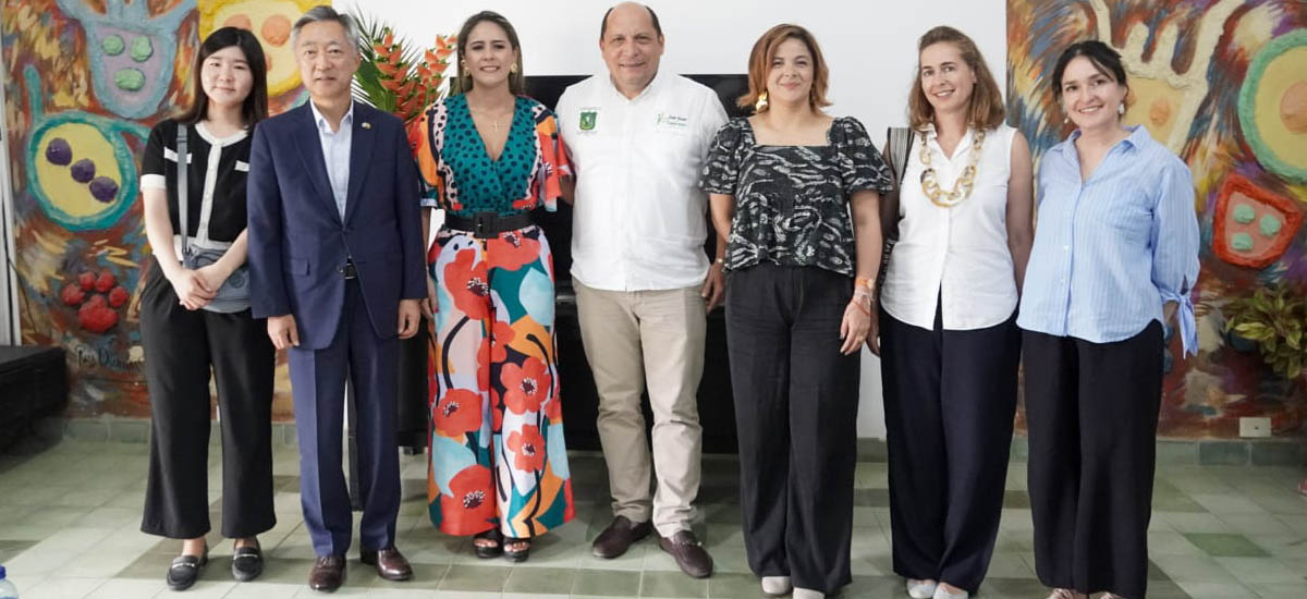La imagen muestra a un grupo de personas de pie, unas junto a otras, posando para una foto. En total son ocho personas, algunas de las cuales llevan corbata. Todos visten ropa formal, lo que sugiere que podrían estar asistiendo a un evento o reunión especial. El grupo está formado por hombres y mujeres, algunos de ellos situados más cerca de la parte delantera y otros más hacia la parte trasera. Los individuos están colocados de manera que todos encajan en el encuadre, creando una sensación de unidad y camaradería entre ellos.