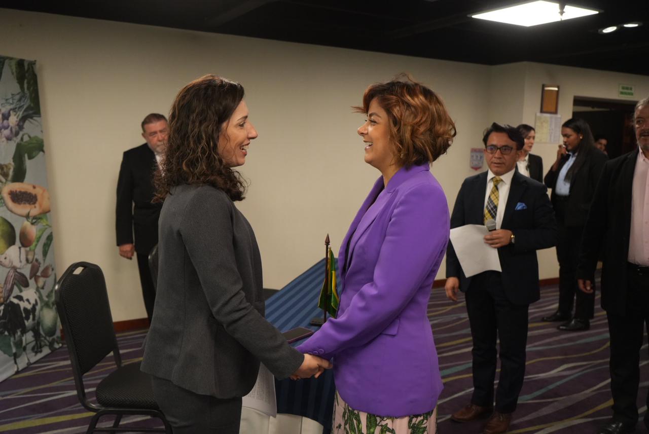 En la imagen se puede apreciar a la ministra de agricultura Jheniffer Mojica tomando de las manos a otra mujer en señal de felicitaciones, se ve que esta muy contenta en un acto publico.