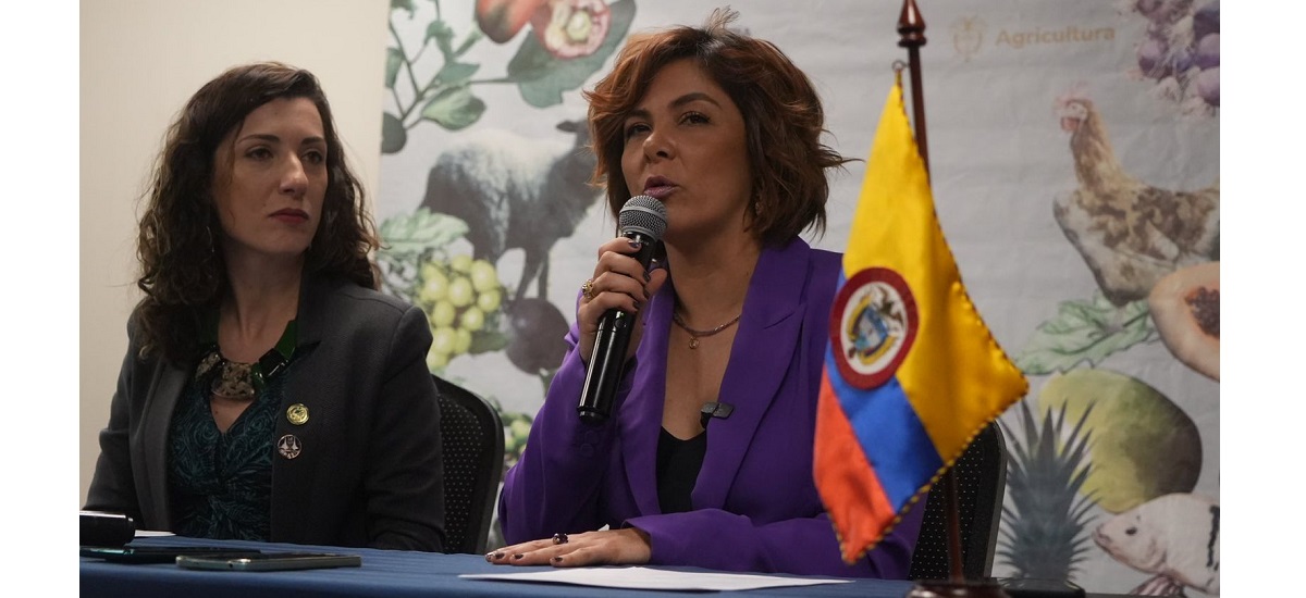 En la imagen se ve a la Ministra Jhenifer Mojica dando una conferencia, se le ve con un micrófono en la mano y con un semblante serio.