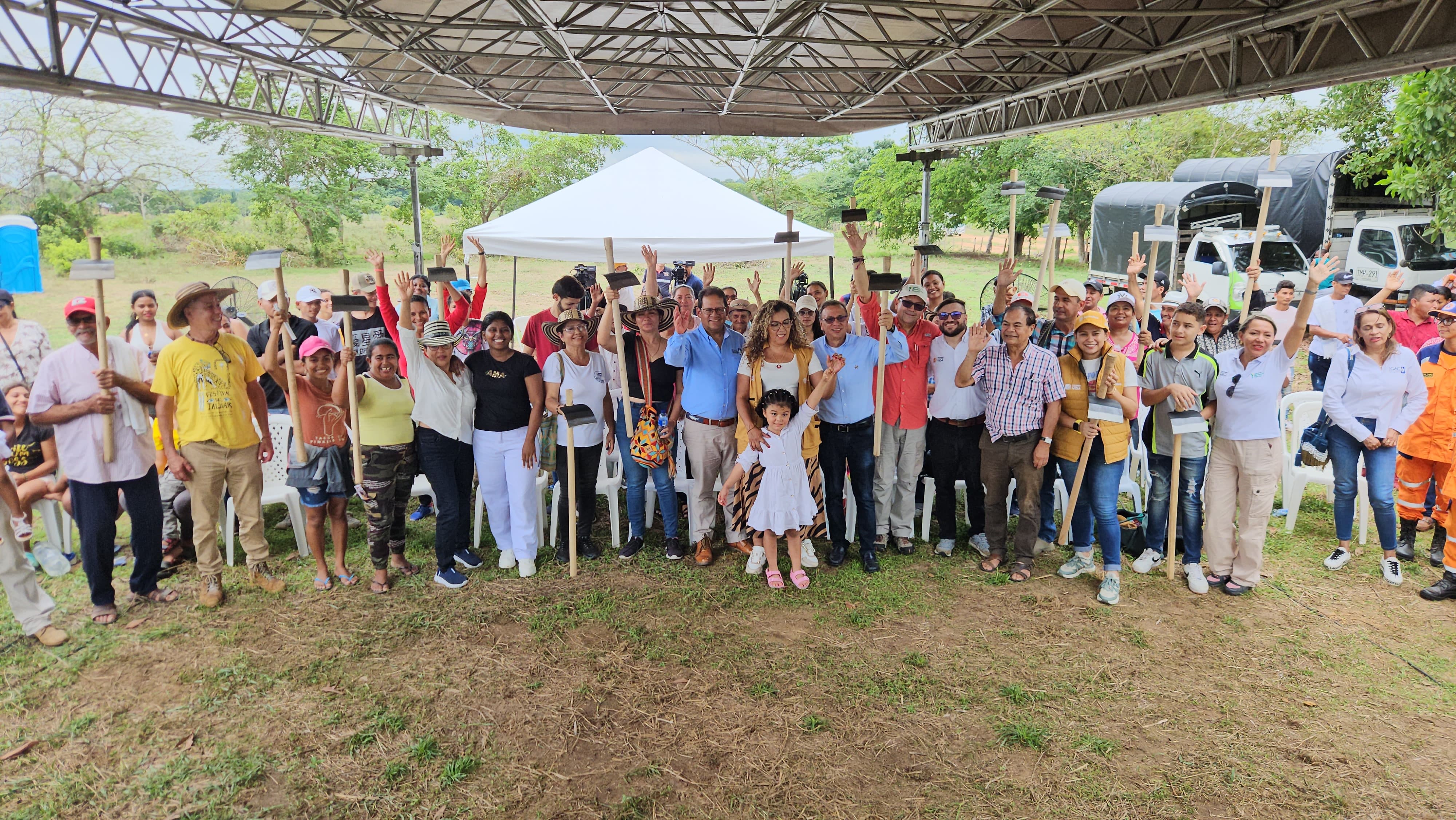 En la imagen se puede apreciar a varias personas reunidas en una zona rural, posando para una foto, se les ve muy alegres.