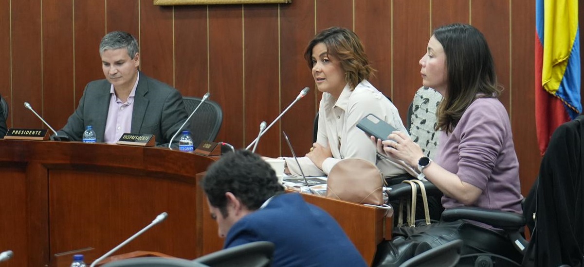 habla por un micrófono, lo que indica que se dirige al público o a los participantes.