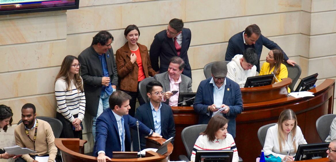 En la imagen se puede apreciar a un grupo de persona reunidas en el congreso dialogando