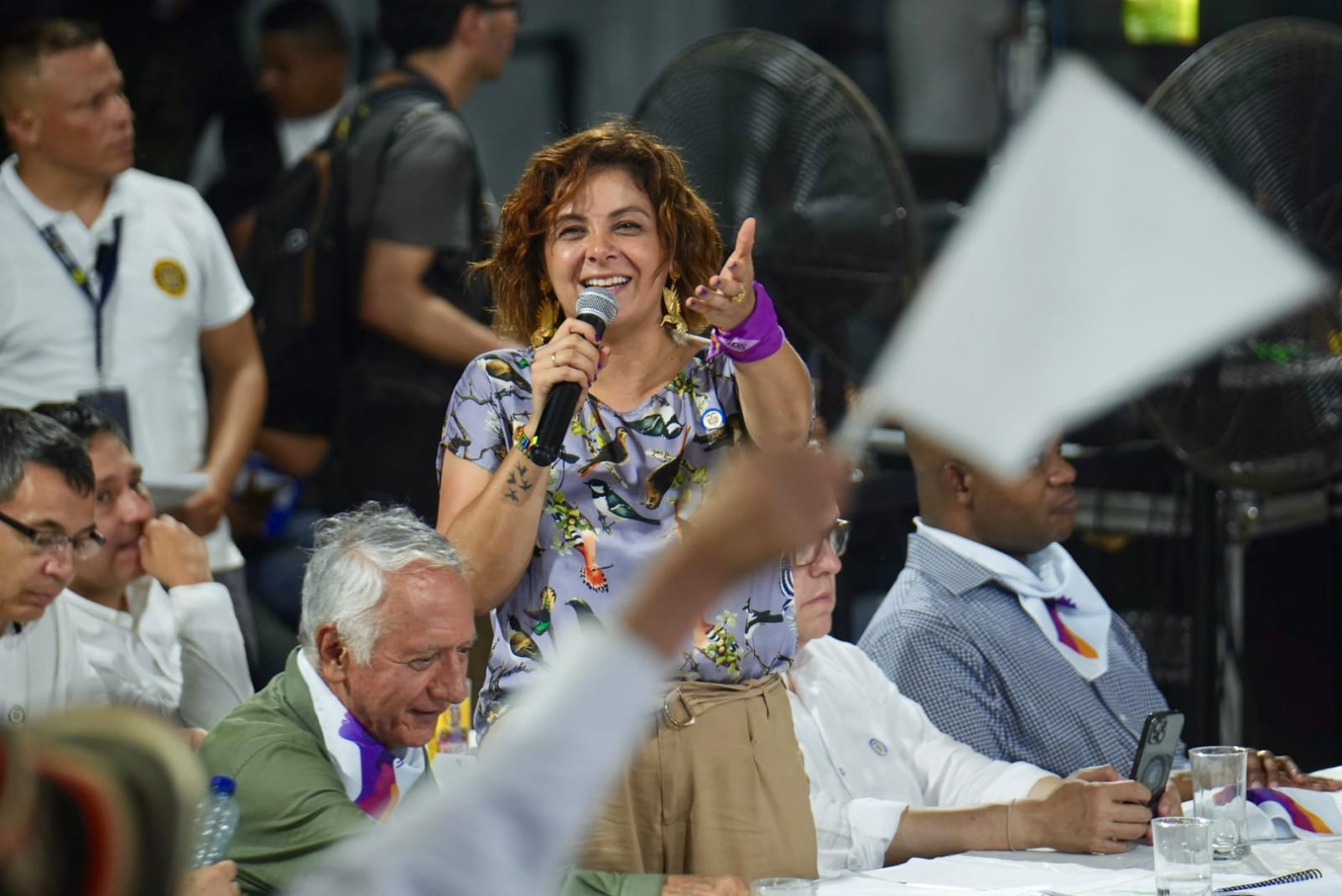 En la imagen se puede ver a la ministra Jhenifer Mojica, con un microfono en la mano, muy contenta en lo que parece una reunión o un acto publico.  